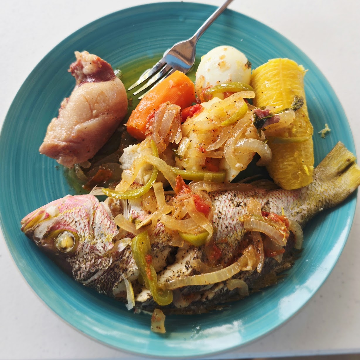 Whole fish meal on a turquoise plate in Placencia